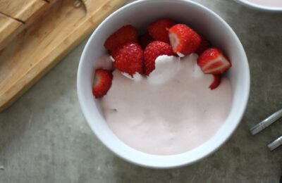 bowl of strawberries covered in strawberry cream