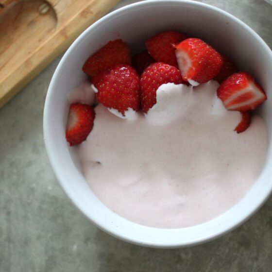 bowl of strawberries covered in strawberry cream
