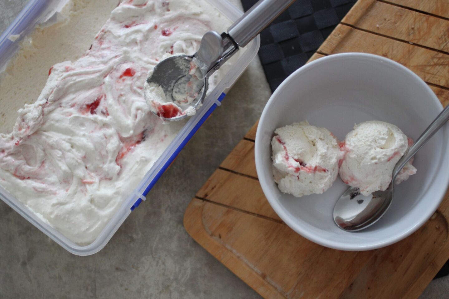 two scoops of soft scoop strawberry swirl ice cream next to pot