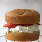 strawberry cream cake on a cooling rack