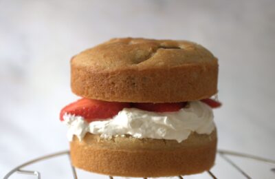 strawberry cream cake on a cooling rack