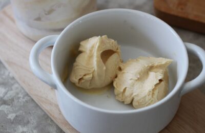 two scoops of vegan melon and peach ice cream in a white bowl