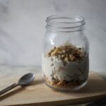 jar of apple cheesecake overnight oats with a spoon beside it
