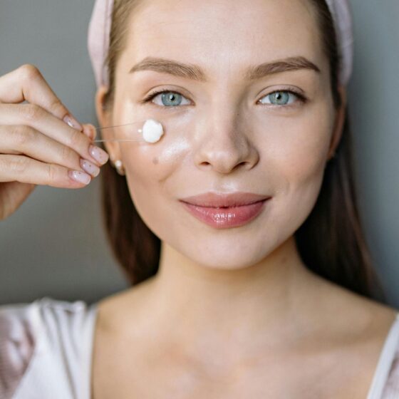 youthful woman applying skincare
