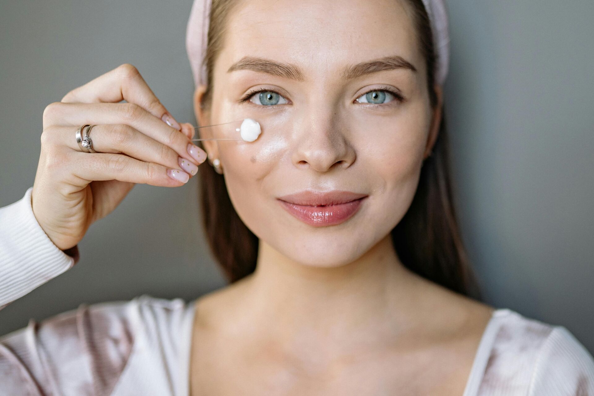 youthful woman applying skincare