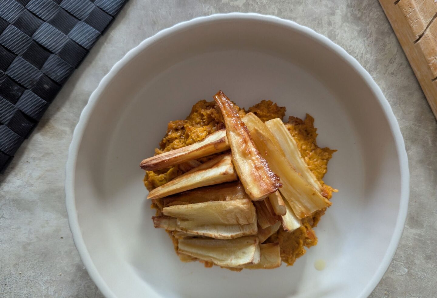 close up shot of a bowl of carrot dip and maple parsnips