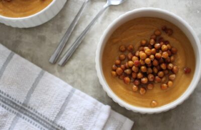 two bowls of spiced sweet potato soup topped with chickpeas