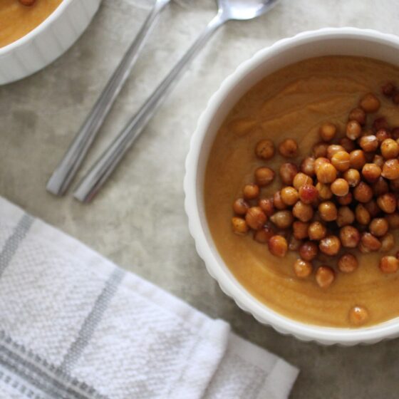 two bowls of spiced sweet potato soup topped with chickpeas