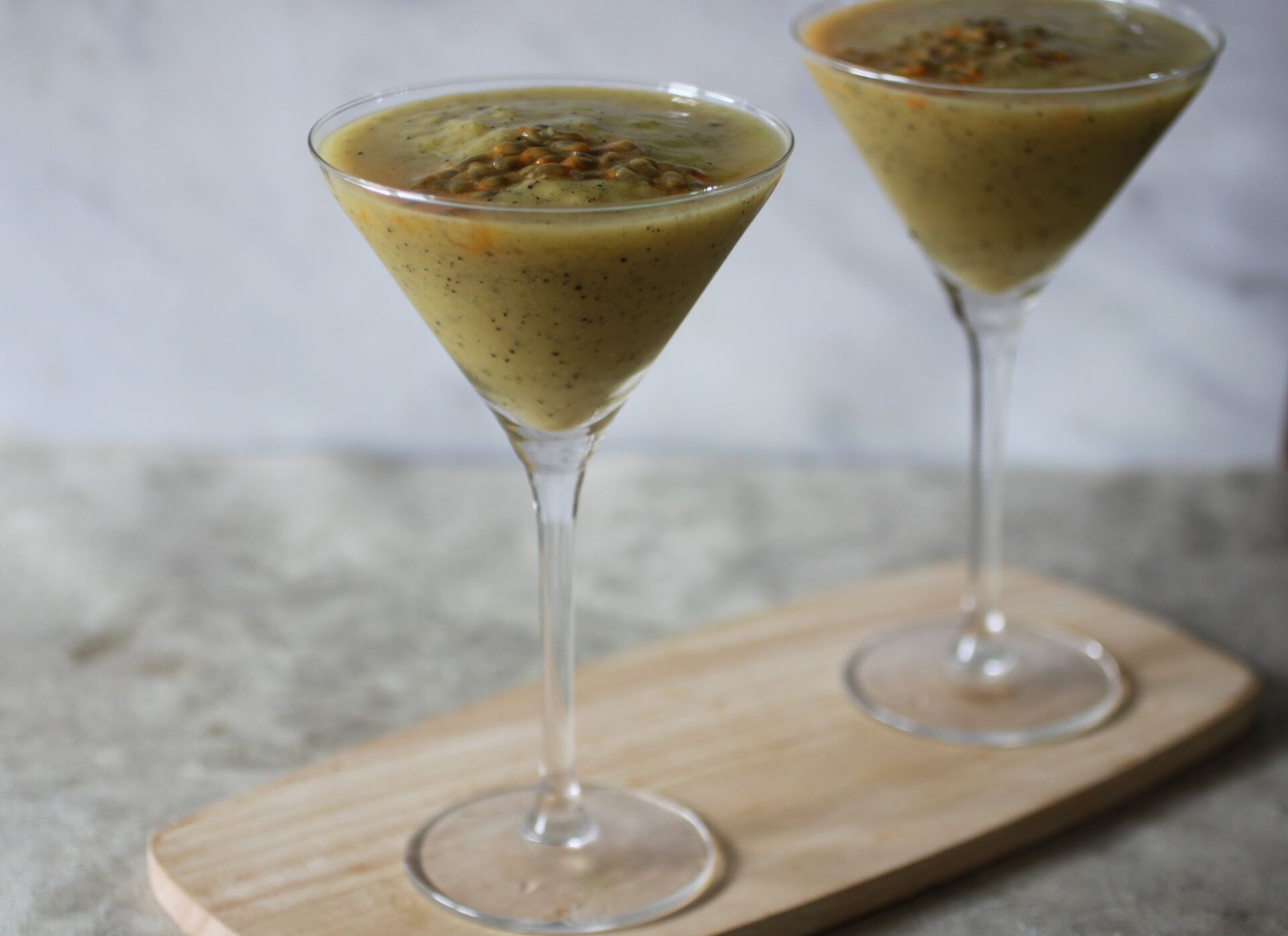 two frozen tropical mocktails in martini glasses