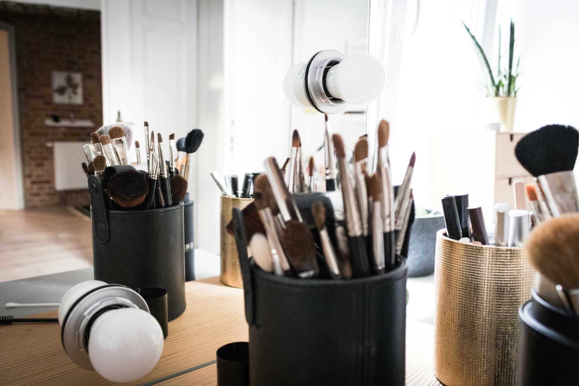 pots of makeup brushes on a table