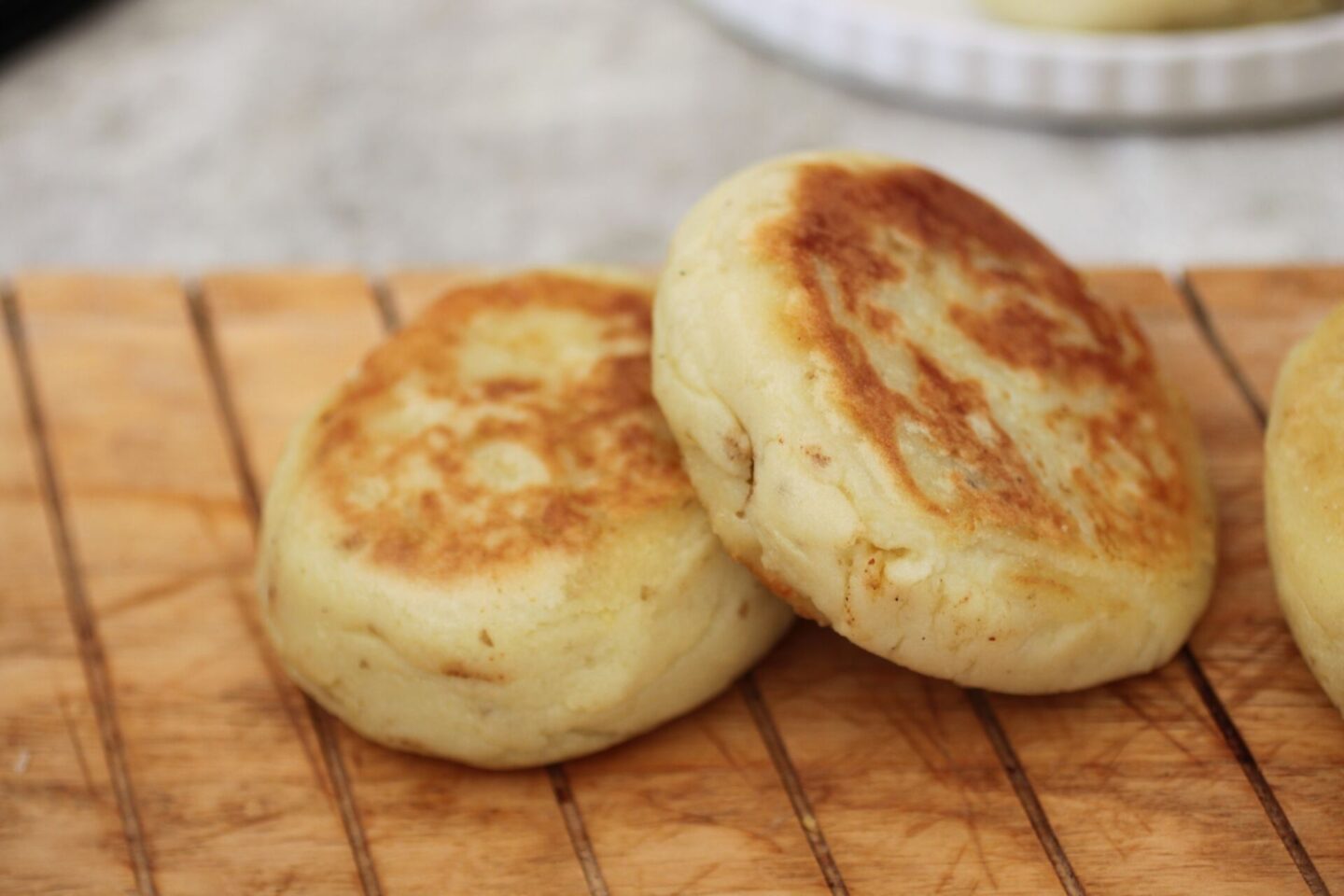 two tandoori cauliflower potato cakes on a wooden tray