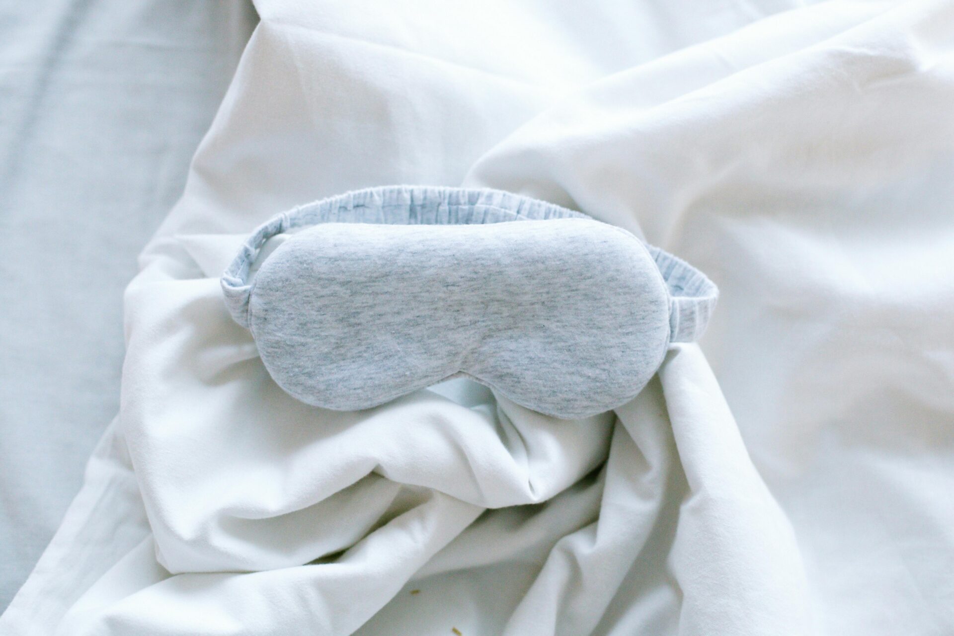 sleep - white sheets with grey eye mask