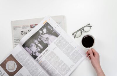 coffee cup next to a newspaper