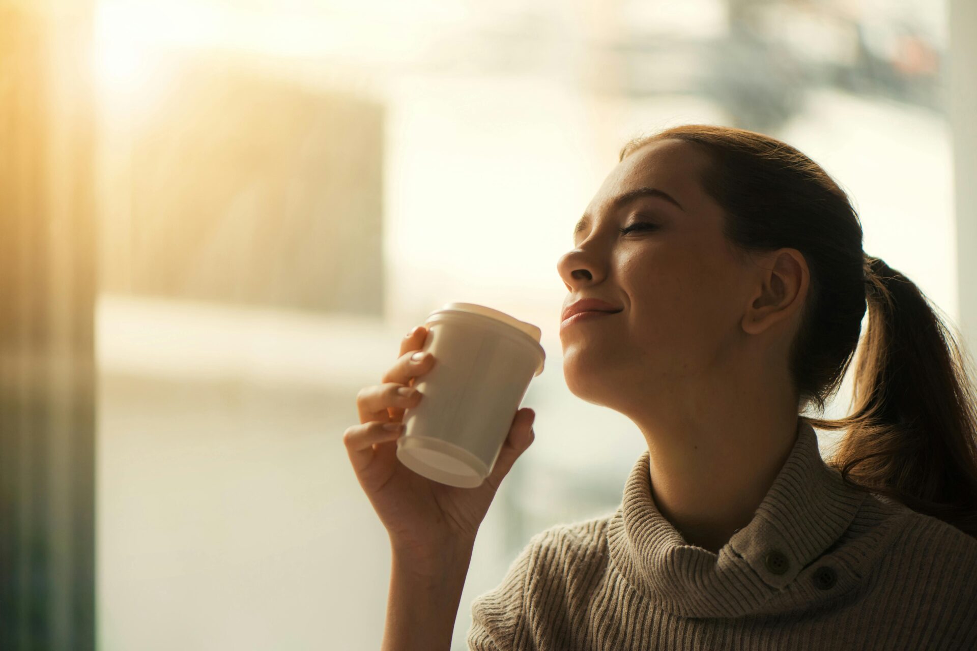 woman about to sip from coffee cup
