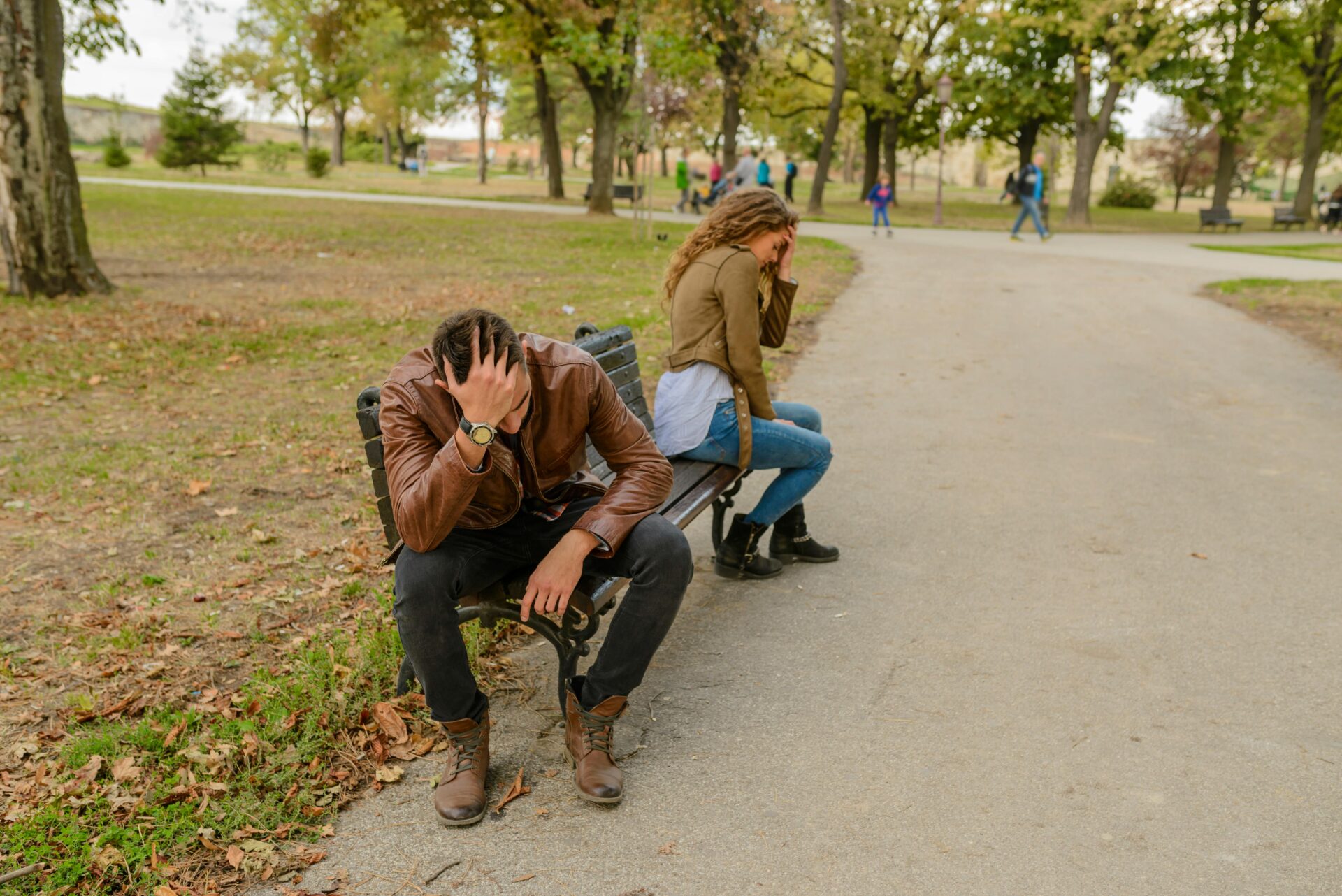 a couple arguing on a bench in a park