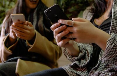 two women holding smartphones