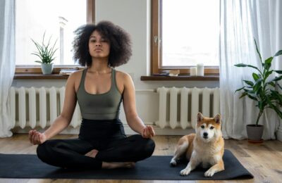 woman doing yoga at home with dog